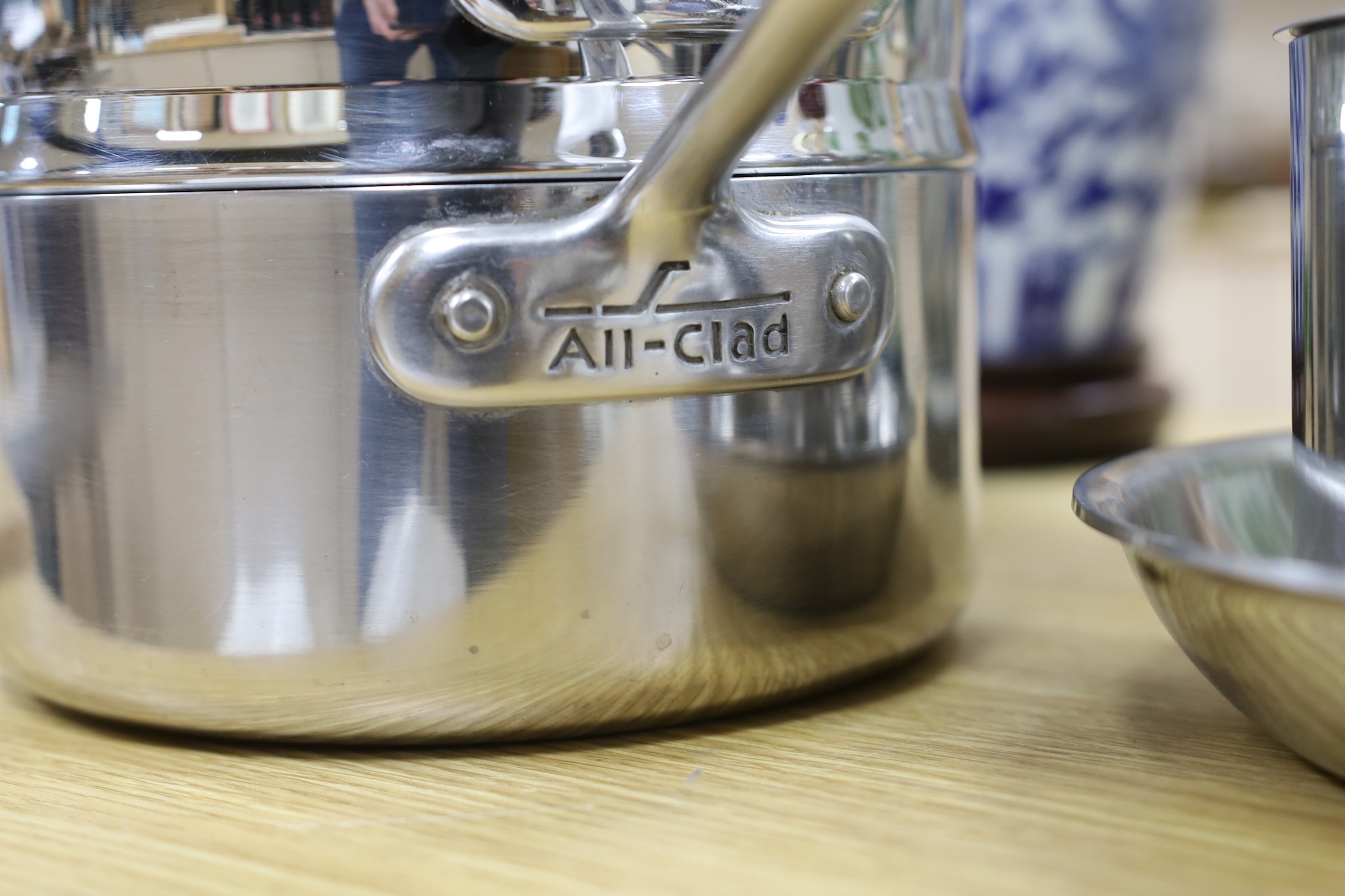 An “All Clad”, stainless steel steamer saucepan and cover, two other saucepans and covers and a matching frying pan, steamer 16cms high